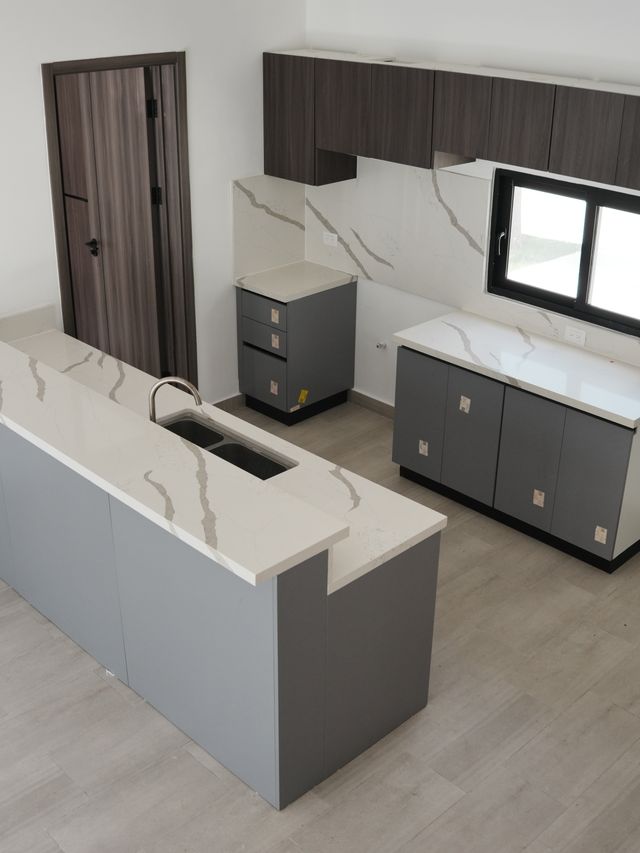 Cocina terminada en Villas Waves, Bávaro, con isla de cuarzo y gabinetes grises
