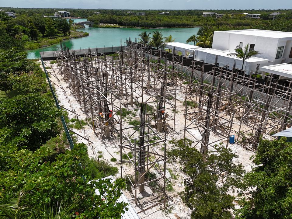 Villa frente a laguna: estructura y andamios junto al agua