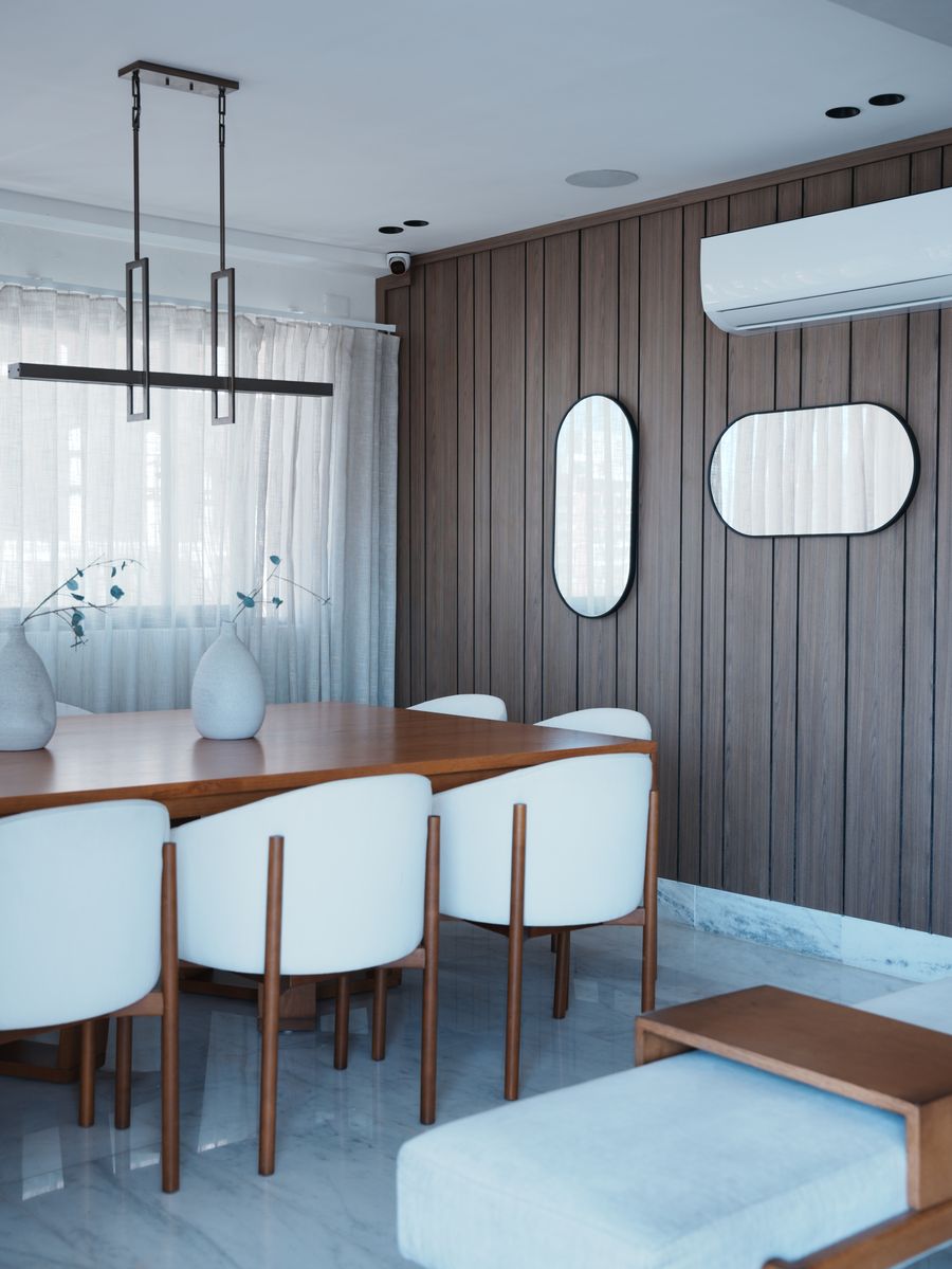 Pent-House Familiar en Renacimiento: comedor con mesa de madera, sillas blancas, lámpara lineal y pared de listones