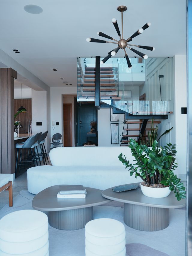 Sala del Pent-House Familiar en Renacimiento con sofá blanco y escalera flotante de vidrio