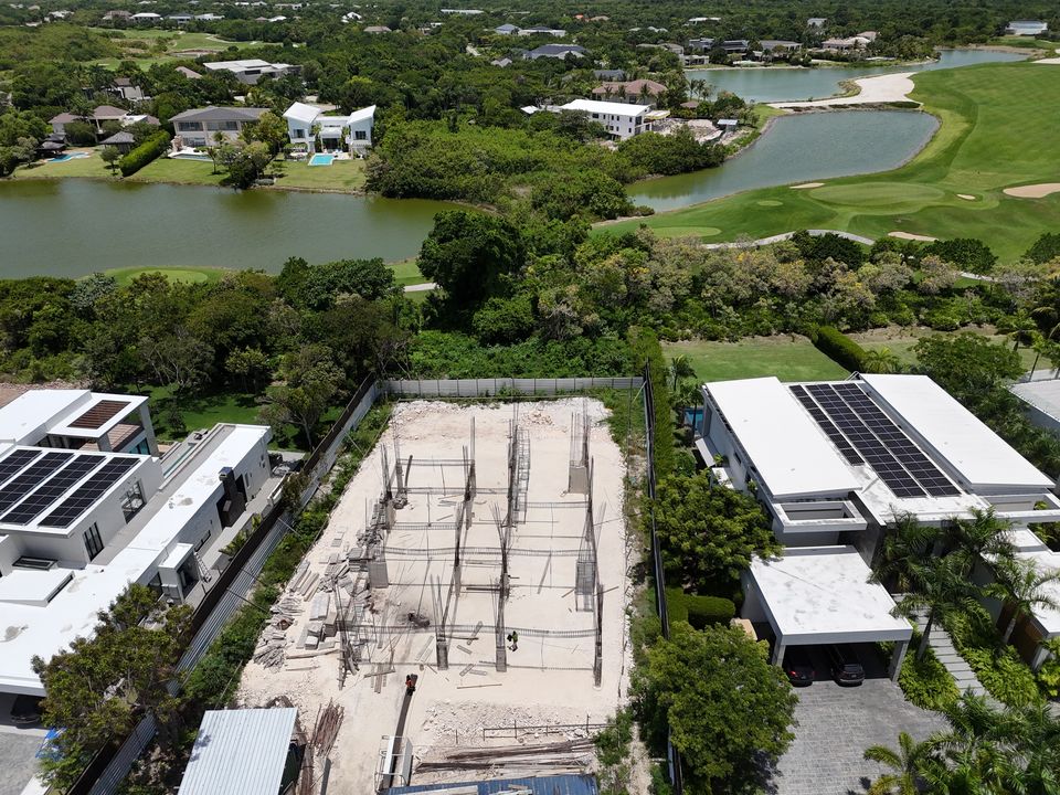 Villa en Hacienda Punta Cana: vista aérea de la estructura en obra gris junto al campo de golf y un lago